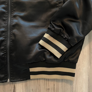 Side view of the satin bomber jacket—ribbed cuffs, collar and subtle sheen.