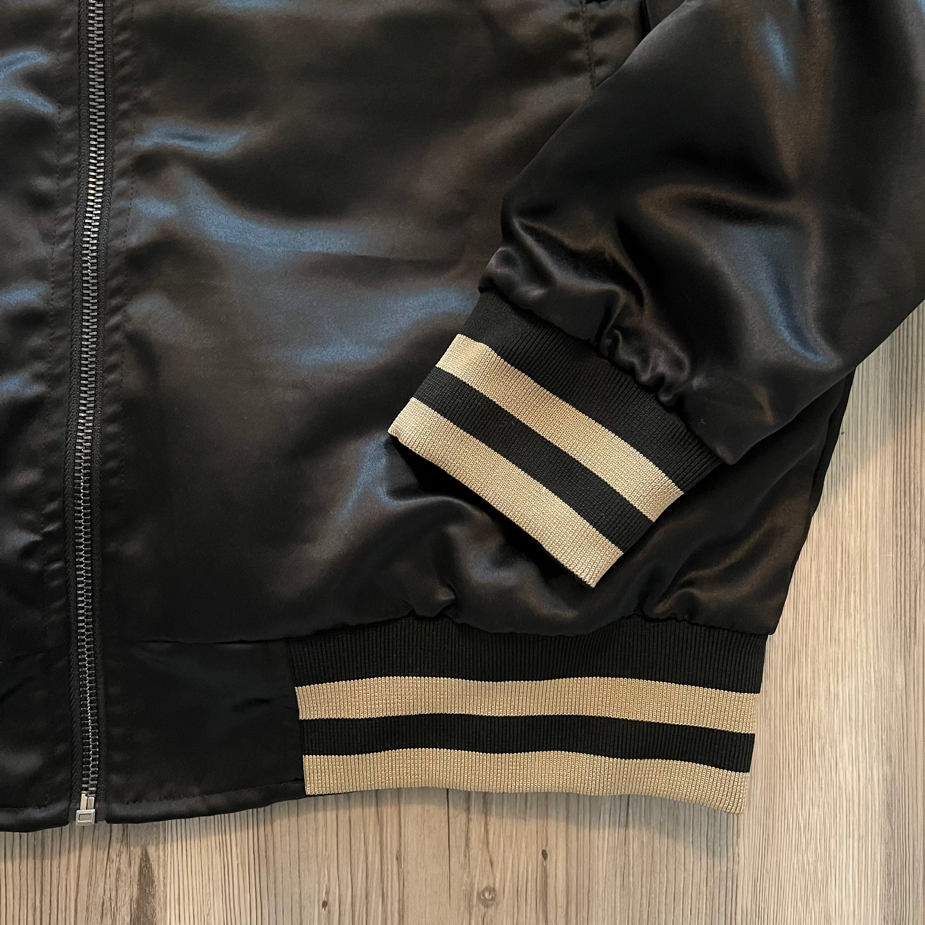 Side view of the satin bomber jacket—ribbed cuffs, collar and subtle sheen.